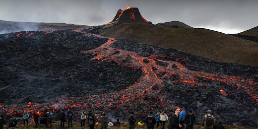  Crowd gather to watch the lava flow from a recent eruption in Iceland (Credits - Marco Di Marco / AP)