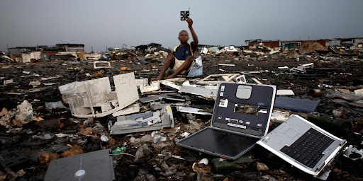 An e-waste worker sitting on a landfill 
