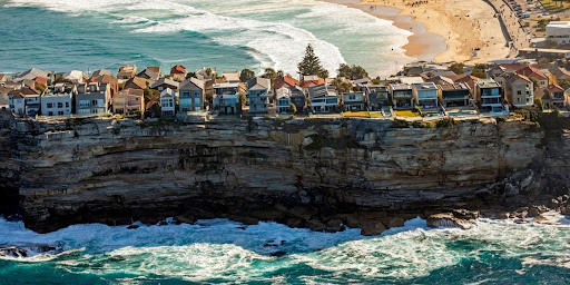 Rocky sea cliffs and houses on Bondi beach, Sydney, Australia